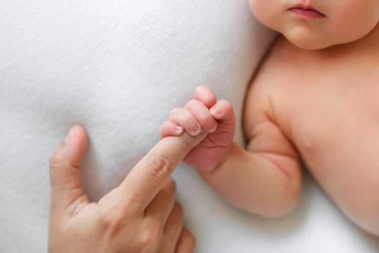 baby haelt finger eines erwachsenen